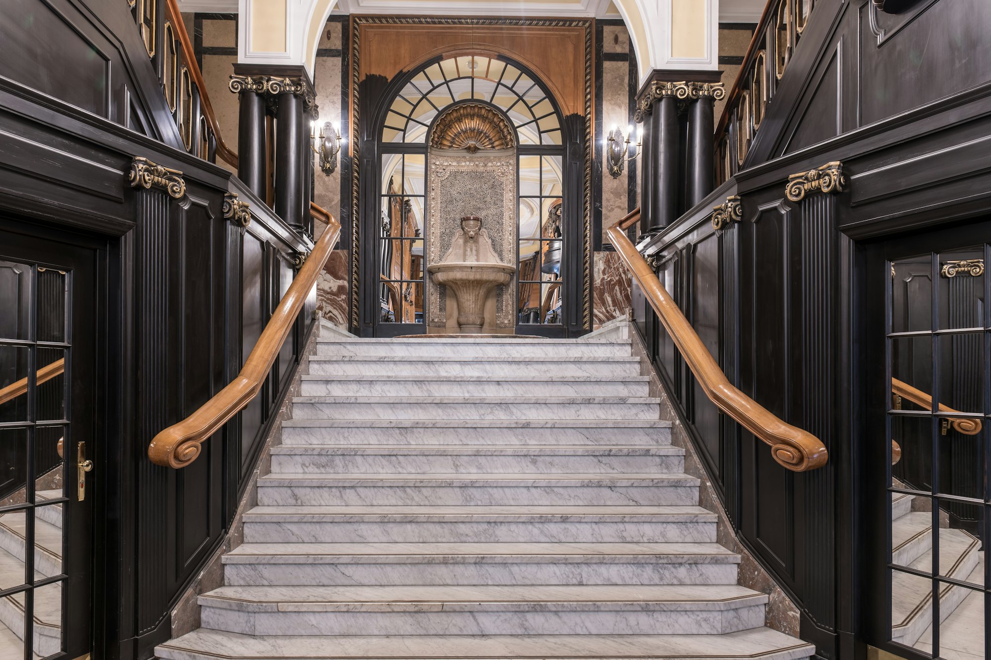 Marble staircase framed by dark panelled walls